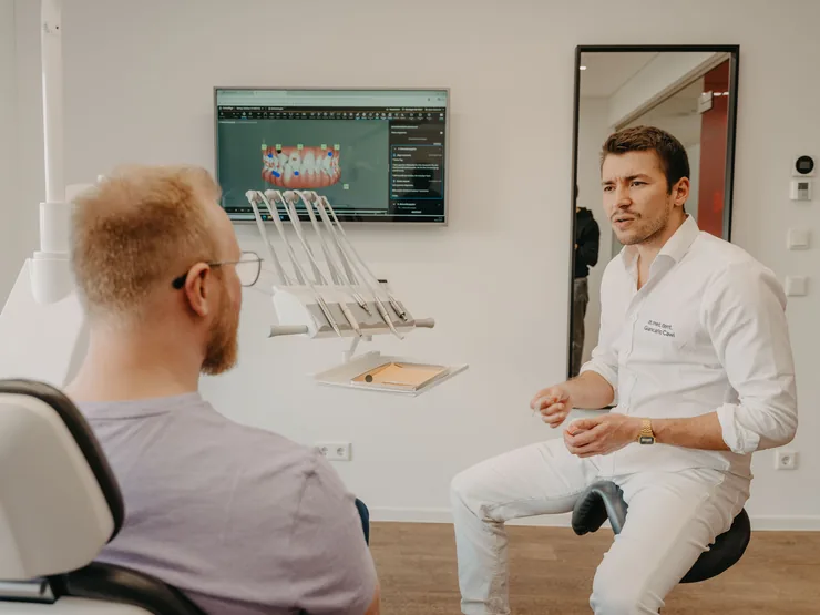 Behandler erklärt einem Patienten die Planung am Bildschirm