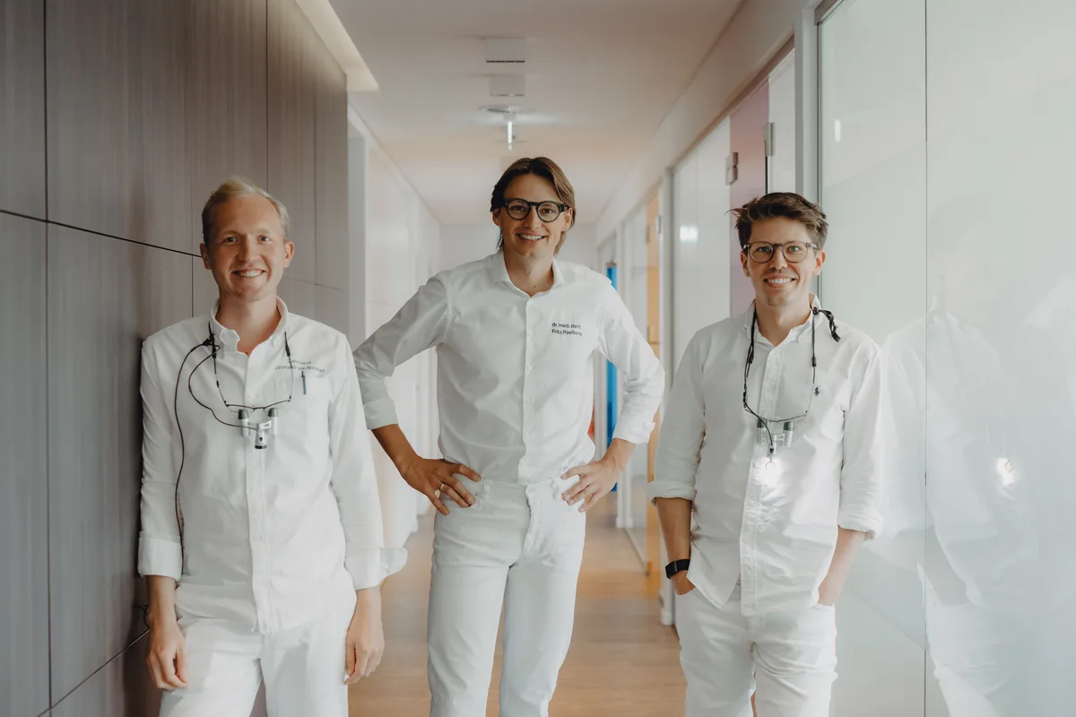 Leonard van Bebber, Dr. med. dent. Fritz Paeßens und Jan Tietze im Flur der Praxis